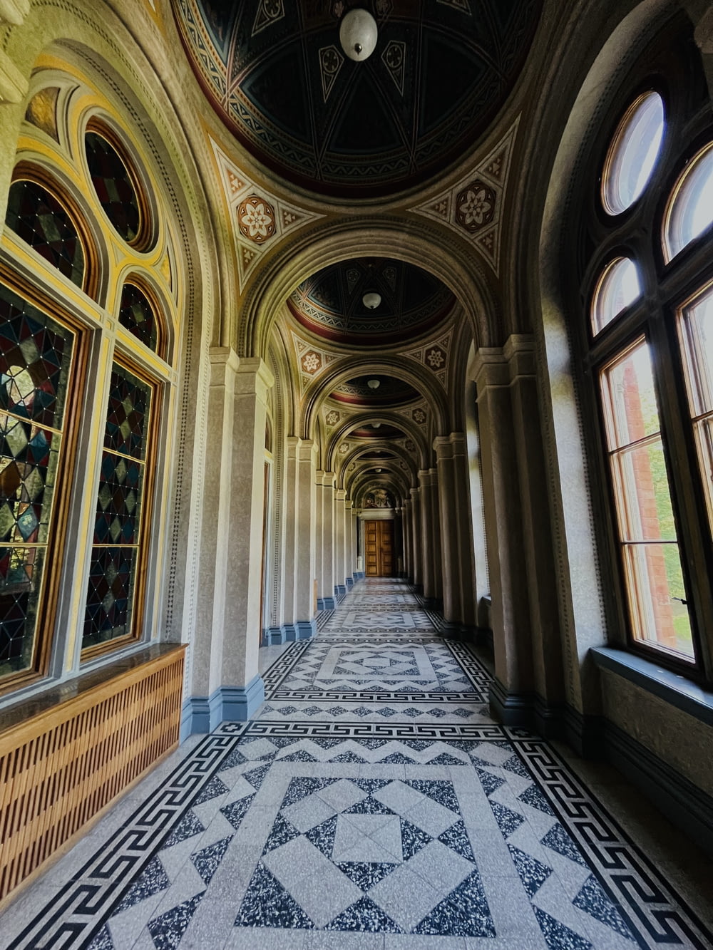 a long hallway with many windows and a tiled floor