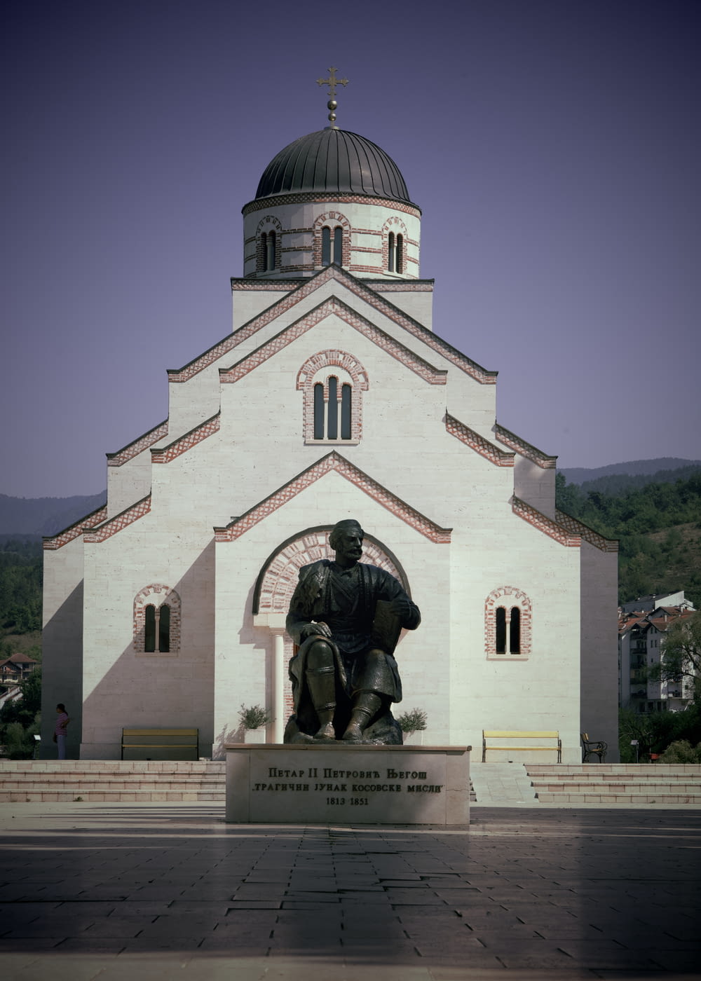 a statue of a man sitting in front of a church