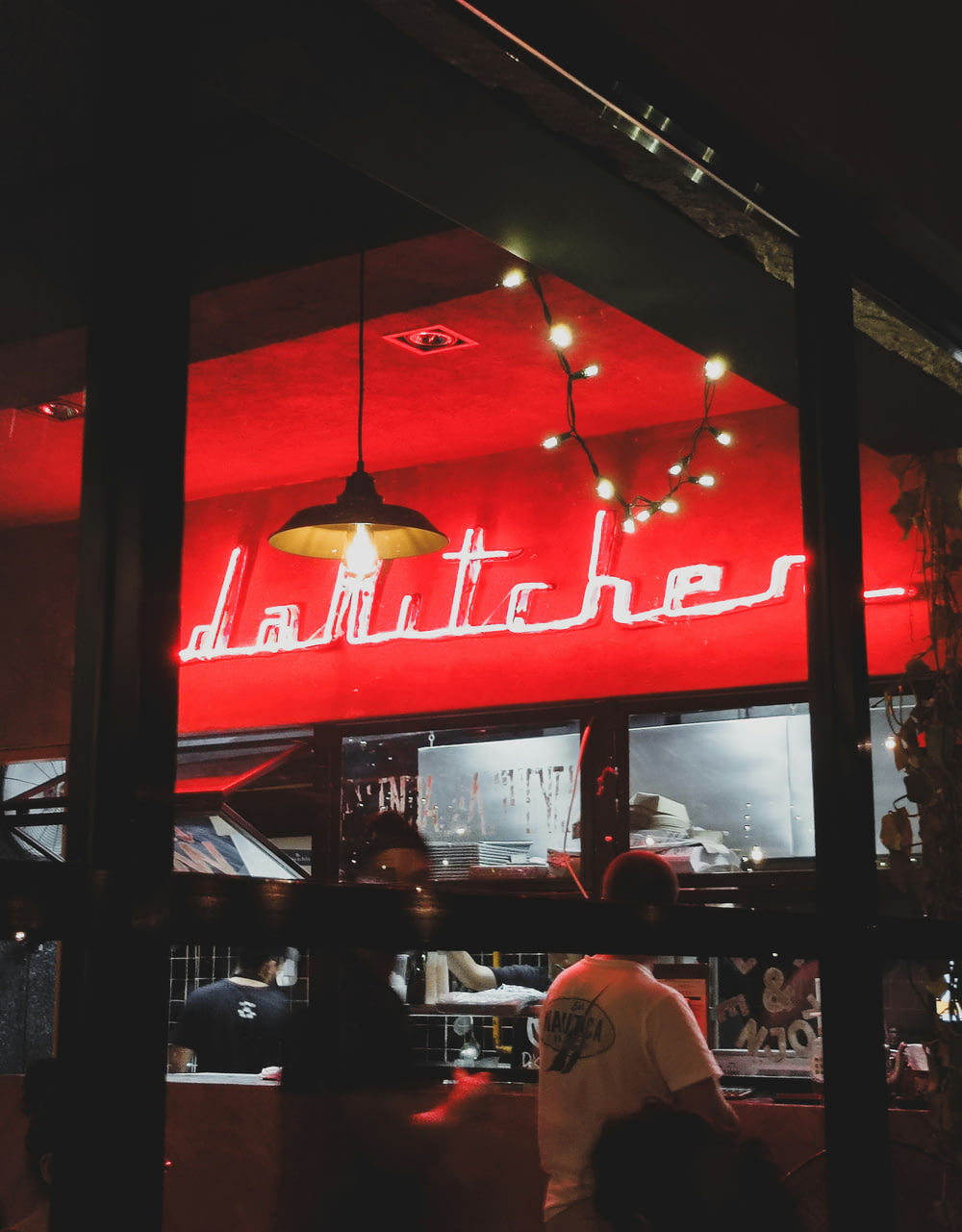 a restaurant with a red neon sign above it