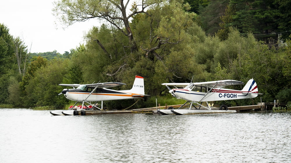 a couple of small planes sitting on top of a body of water