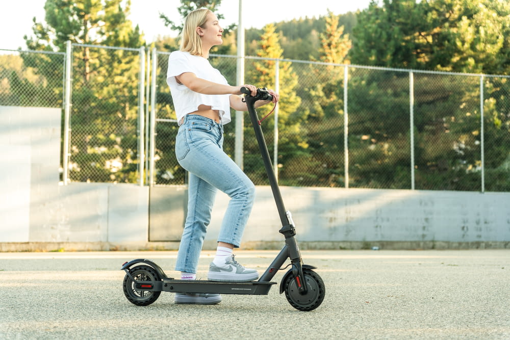 a woman riding an electric scooter in a parking lot