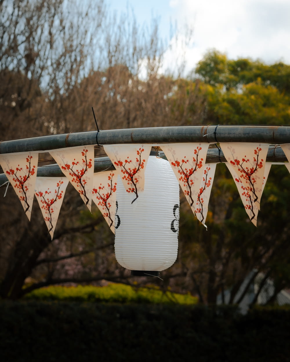 a white paper lantern hanging from a metal pole