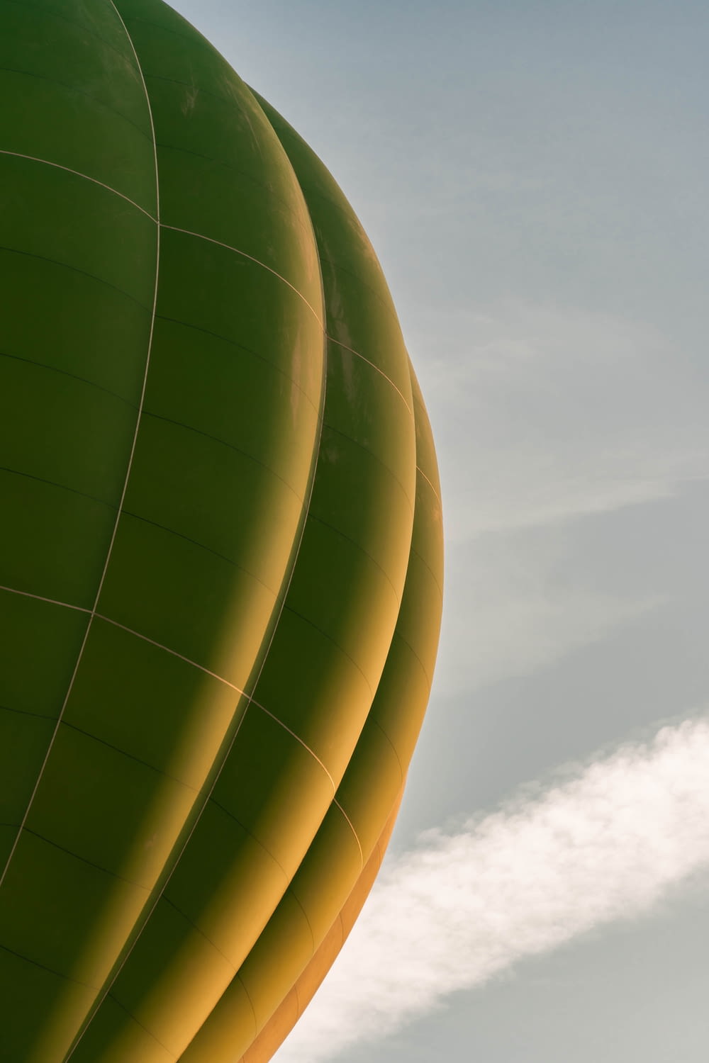 a large green hot air balloon flying in the sky