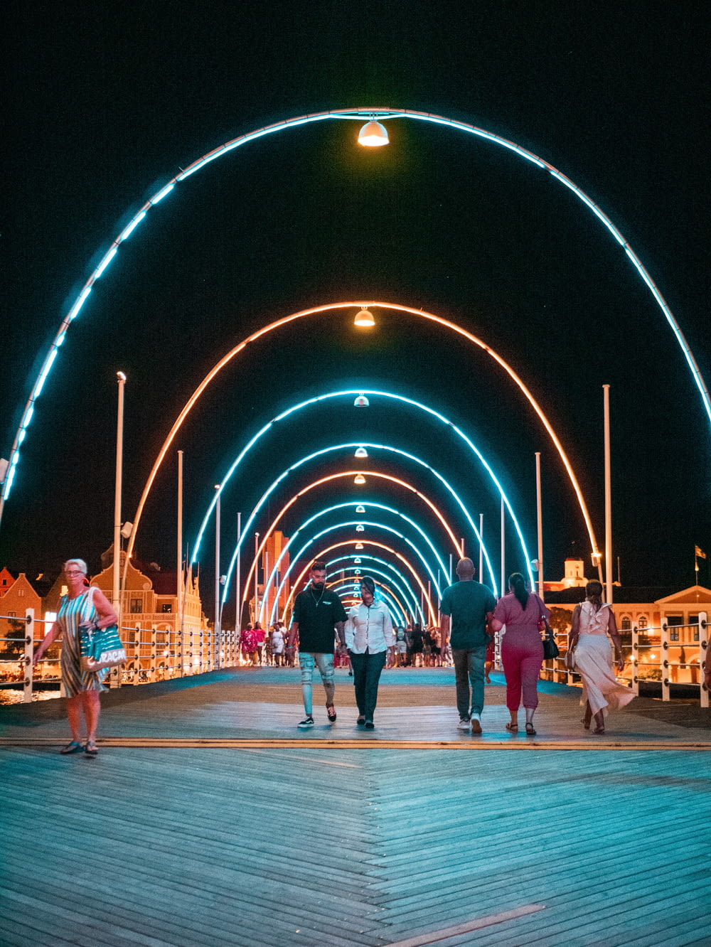 Un gruppo di persone che camminano lungo una passerella di notte