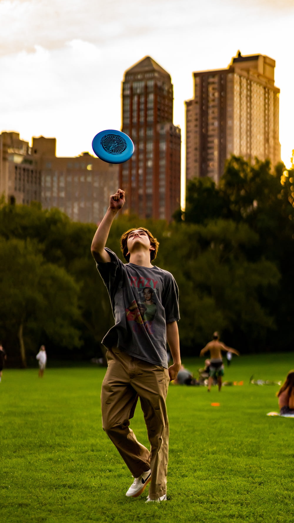 a man in a park catching a blue frisbee