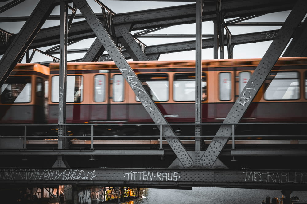 a train traveling over a bridge with graffiti on it