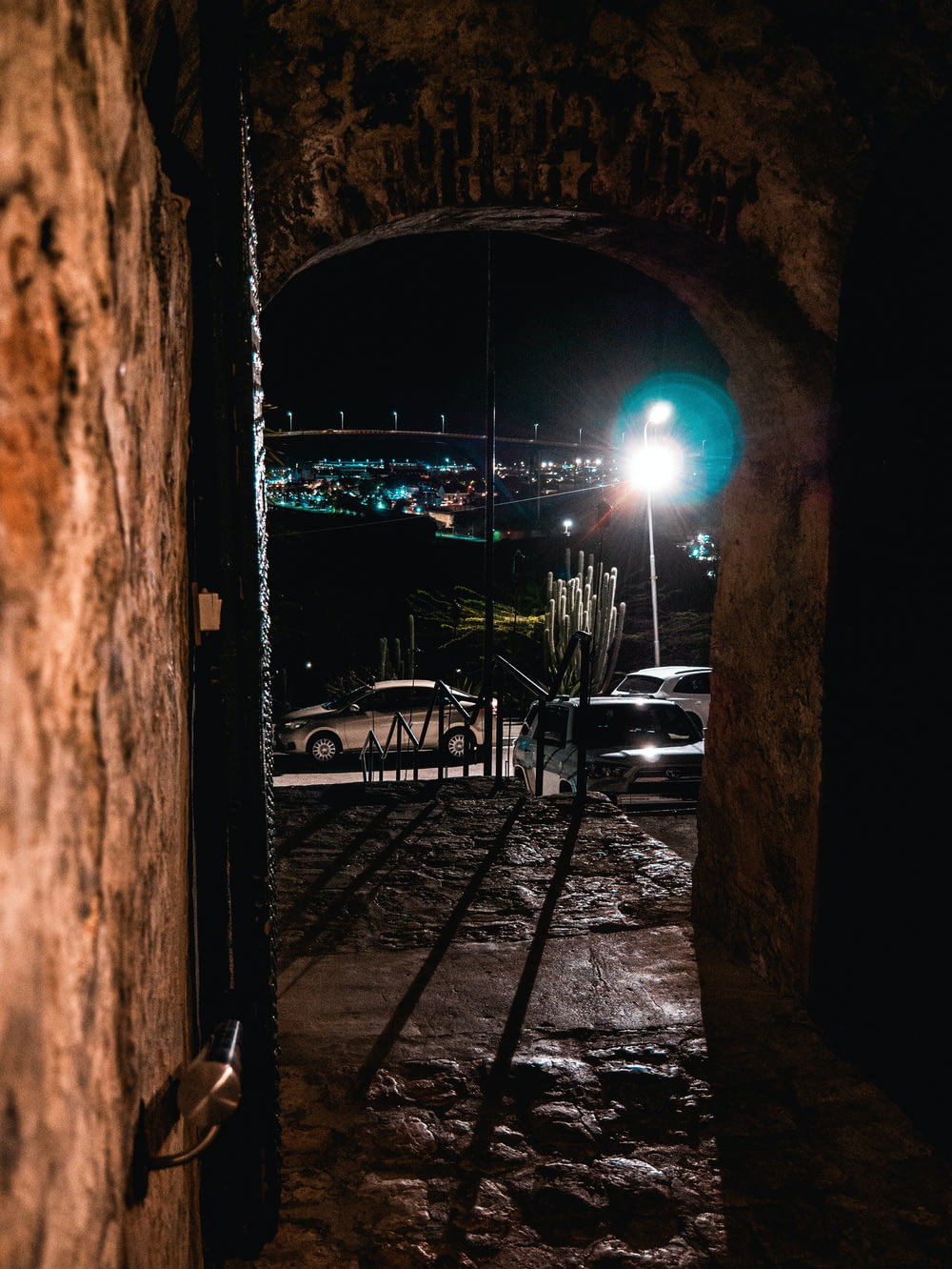 a dark tunnel with a street light in the distance