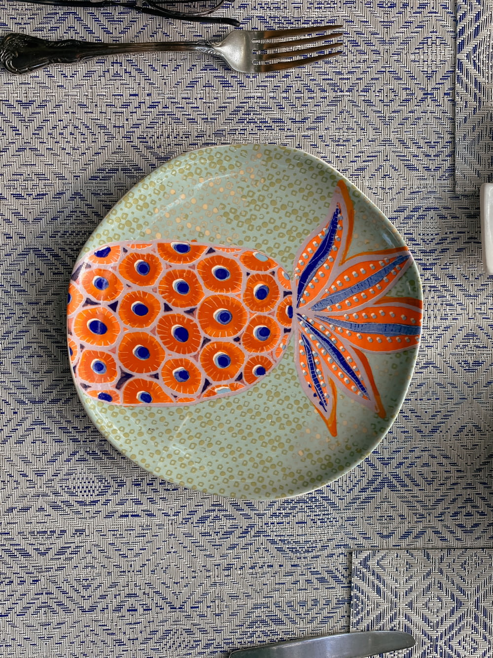 a plate with an orange fish on it