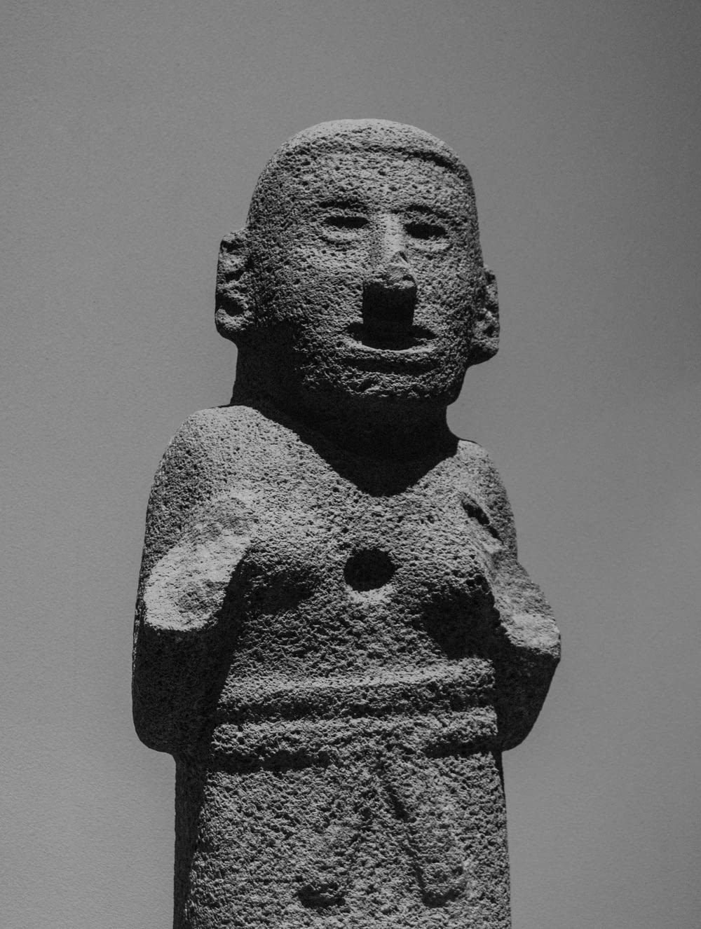 a stone statue of a woman with a bird on her shoulder