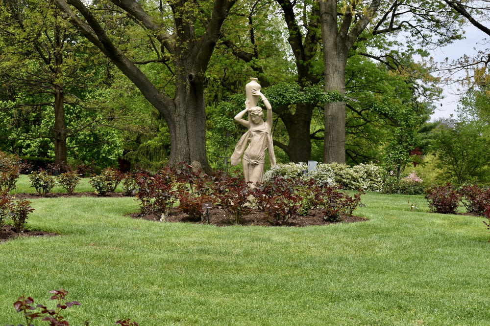 a statue of a woman in a garden