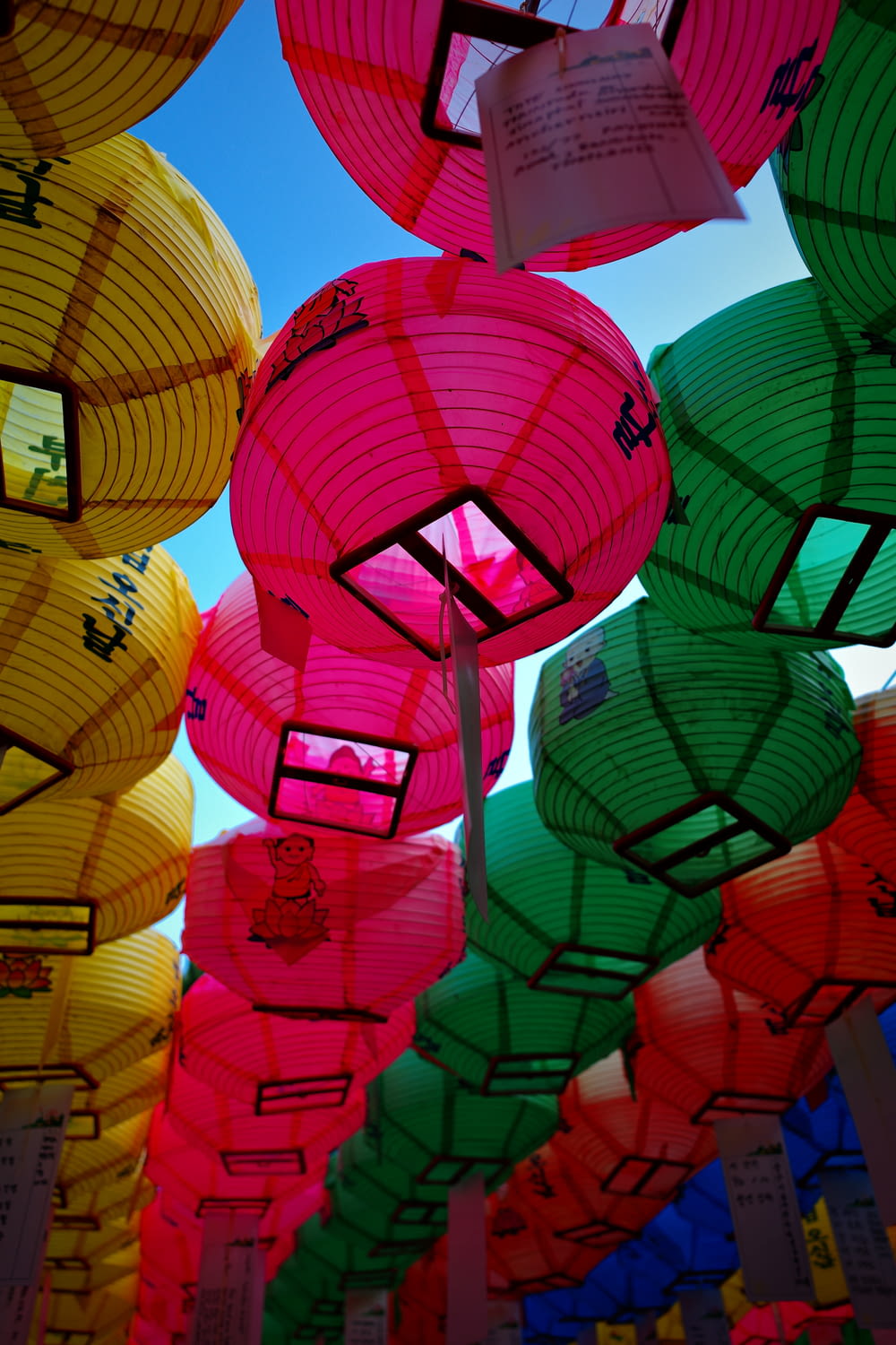 a bunch of colorful paper lanterns hanging from the ceiling