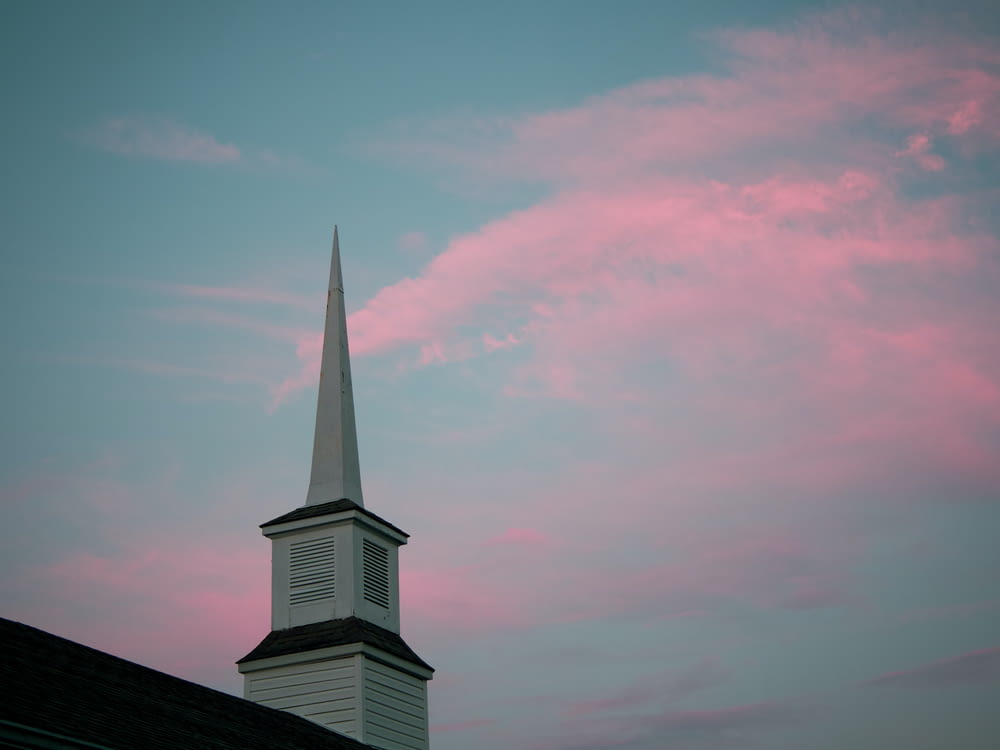 a church steeple with a pink sky in the background