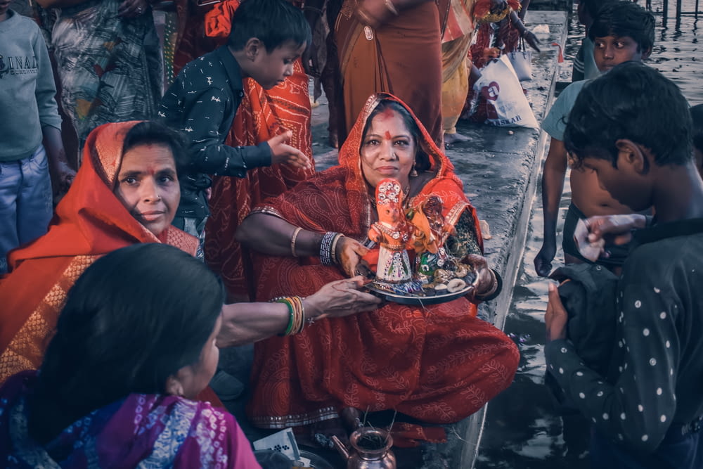 a woman in a red sari holding a plate of food