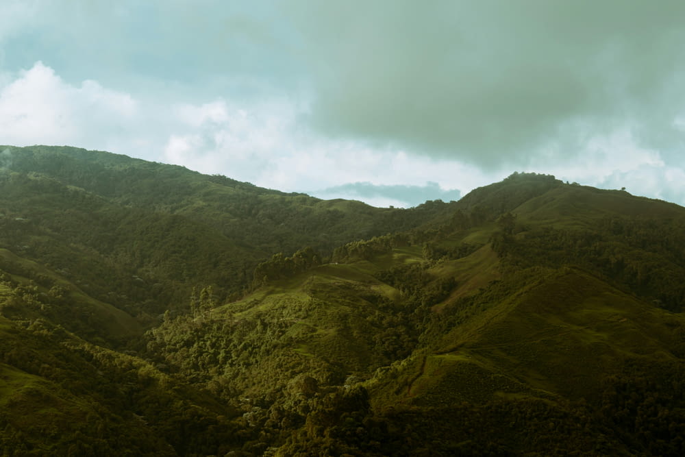a view of a lush green mountain range under a cloudy sky