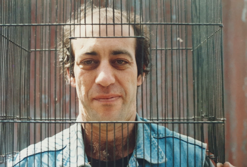 a man in a blue shirt is behind a cage