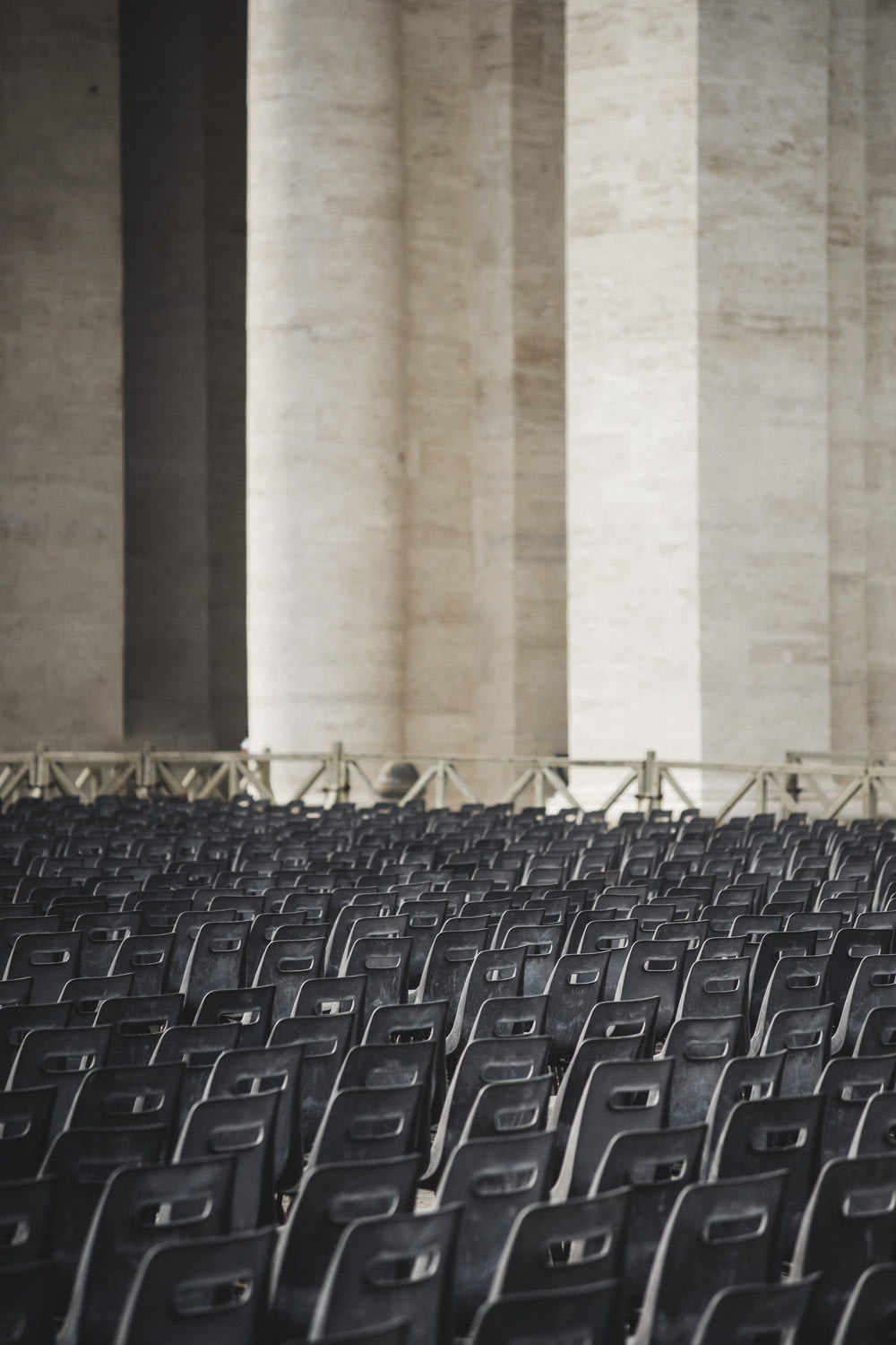 rows of black chairs in front of columns