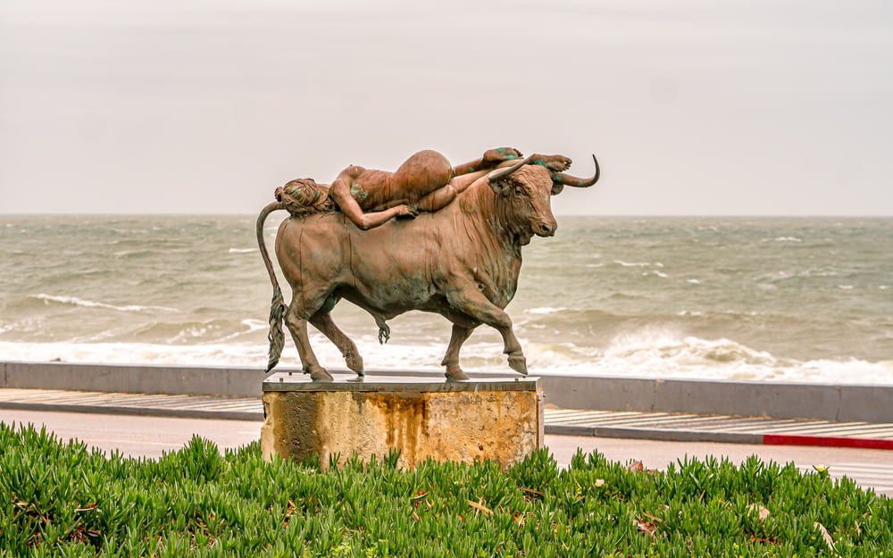 a statue of a woman laying on top of a bull