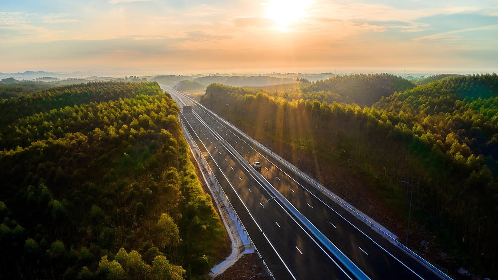 an aerial view of a highway surrounded by trees