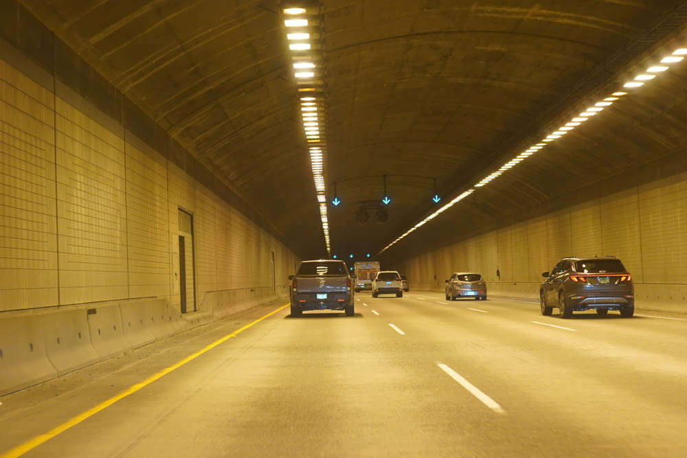 two cars driving down a tunnel in the middle of the night
