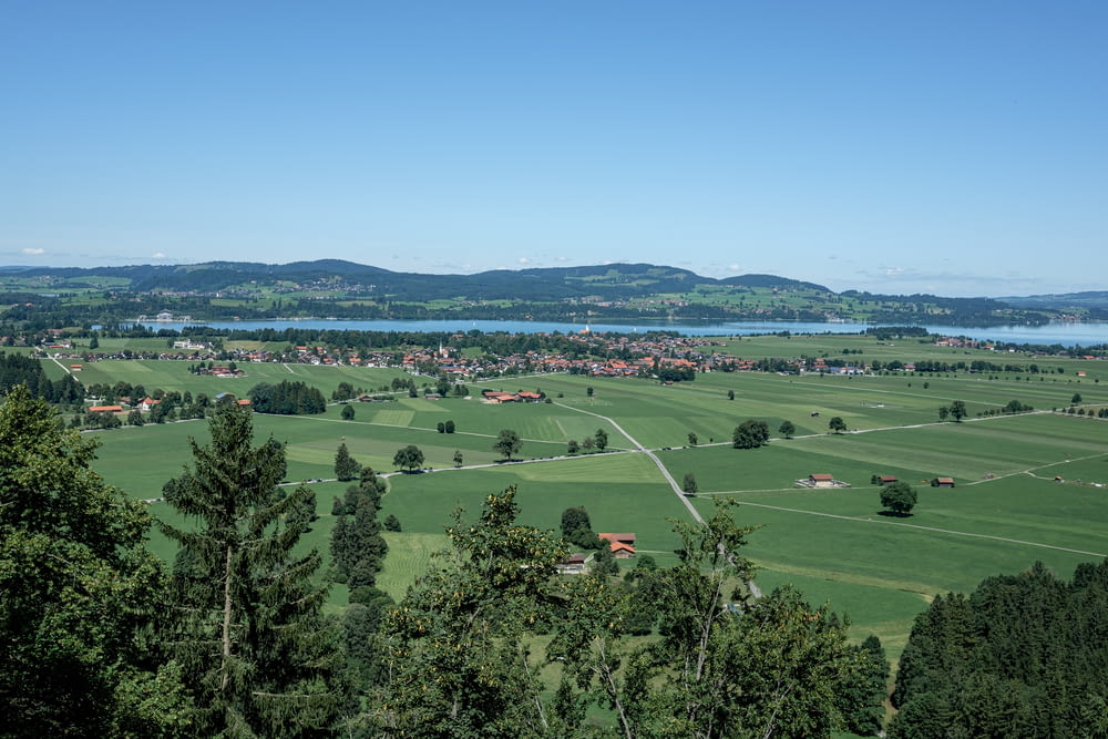 a scenic view of a green valley with a lake in the distance