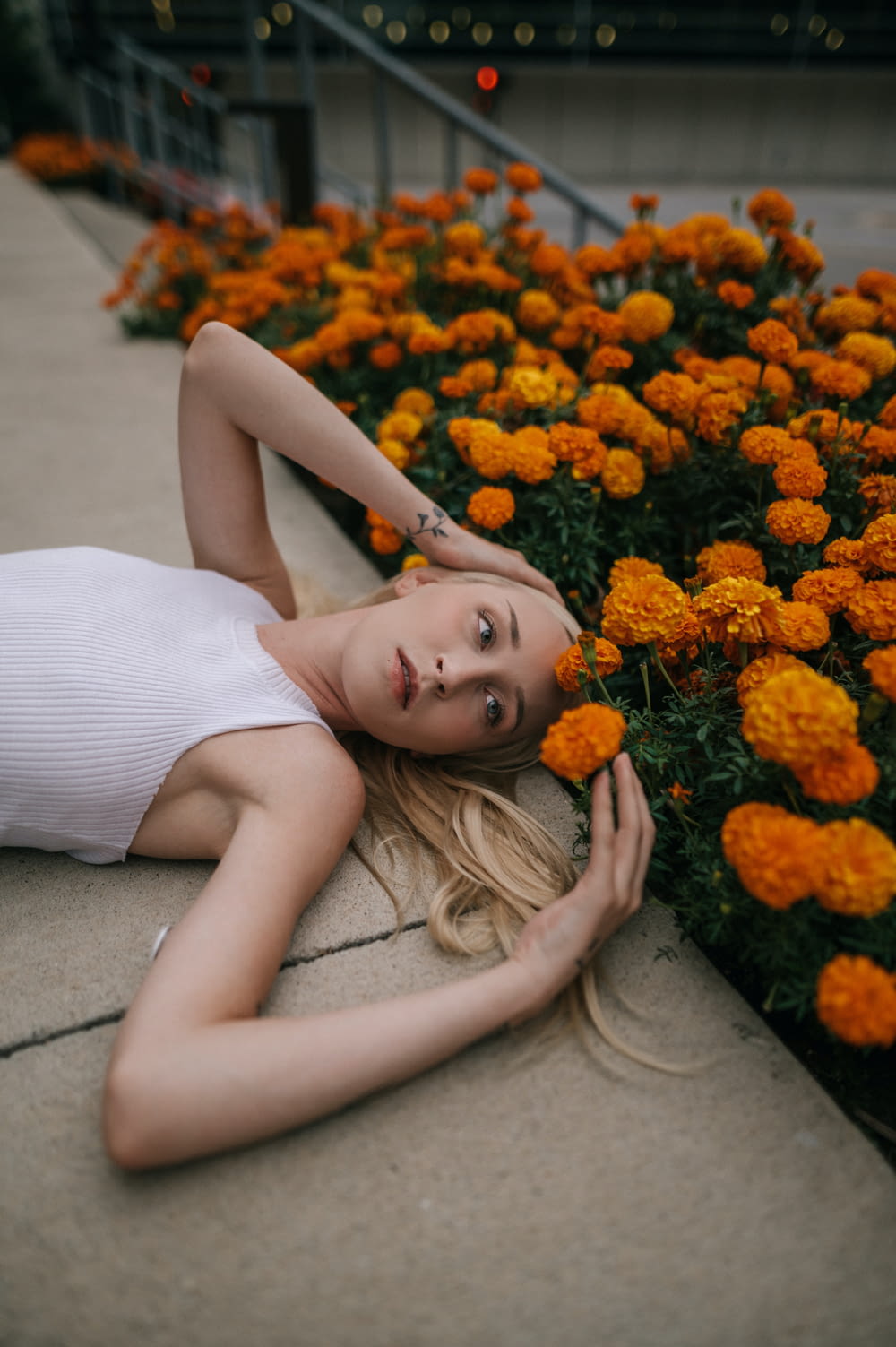 a woman laying on the ground next to flowers