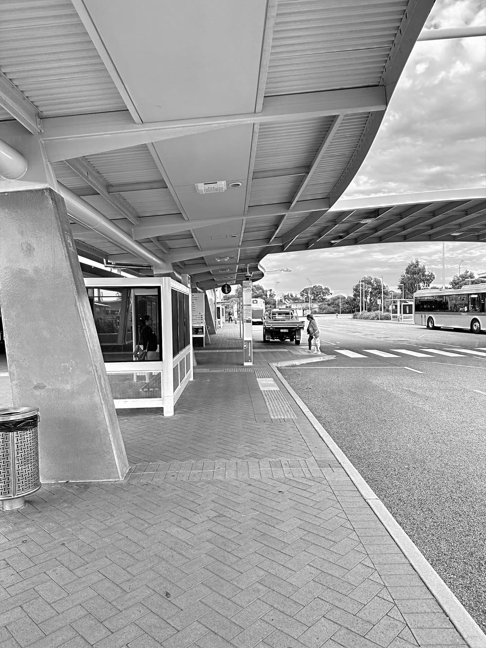 a black and white photo of a bus stop