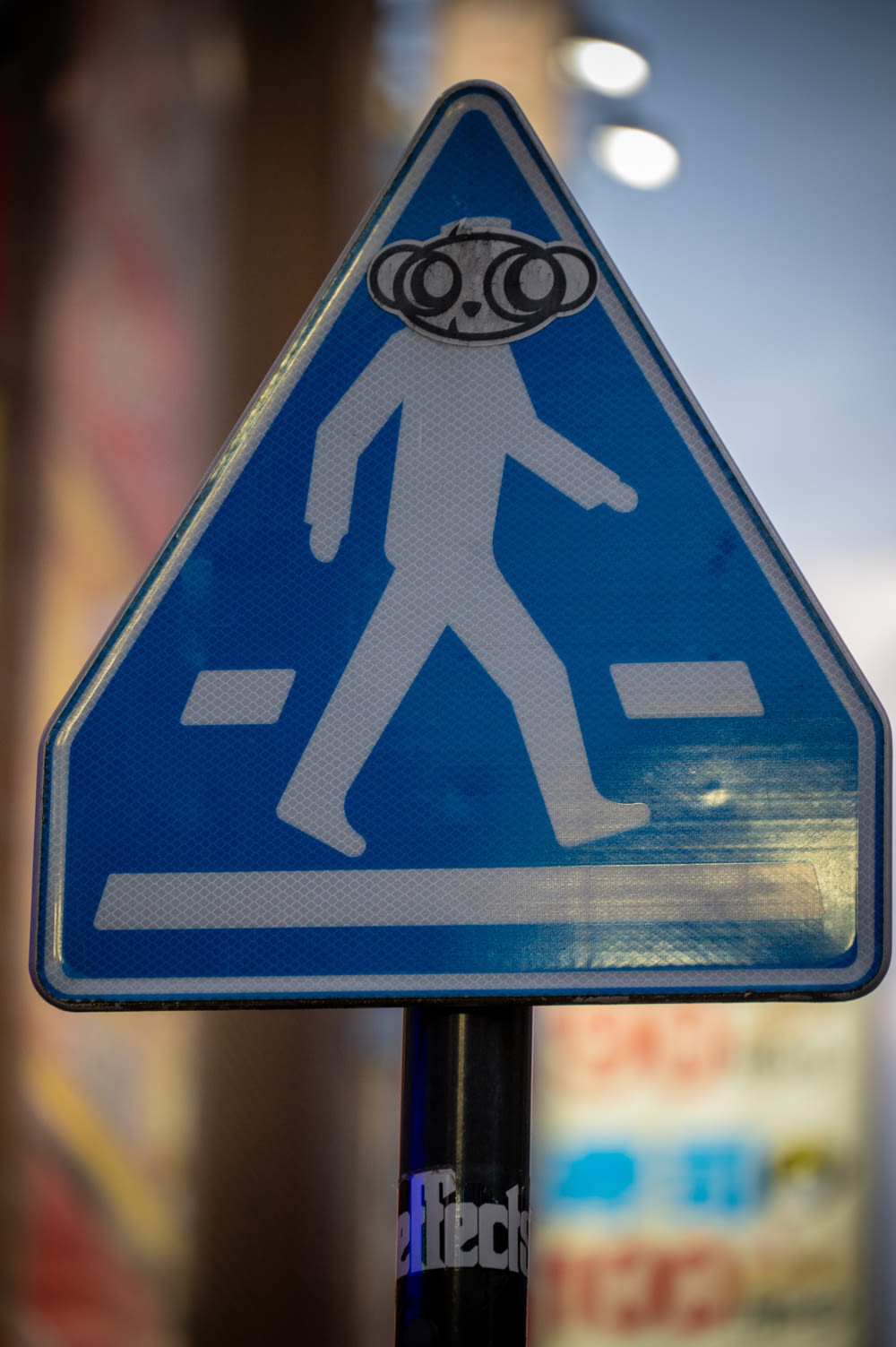un panneau de rue avec un autocollant d’un homme marchant