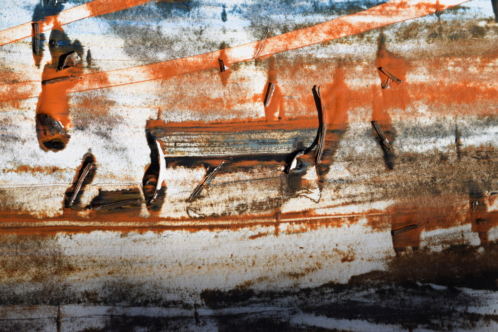 a rusted metal bench sitting in front of a rusted wall