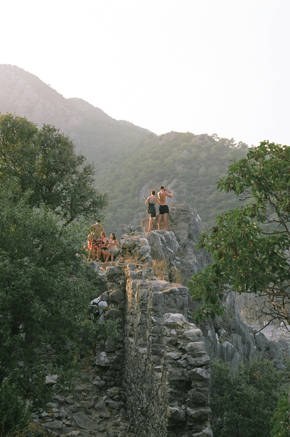 a group of people standing on top of a rocky cliff