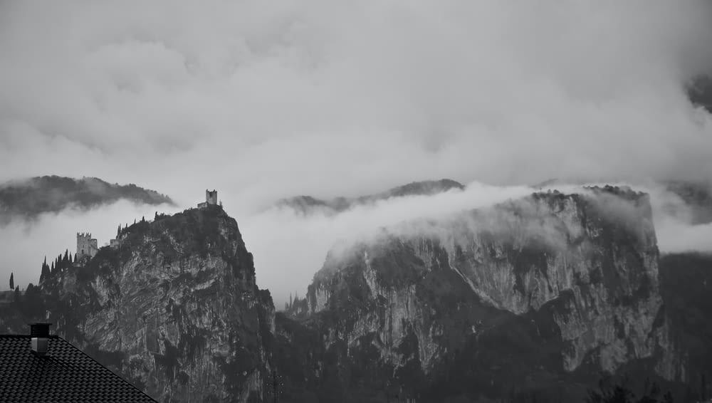 a black and white photo of a castle in the clouds