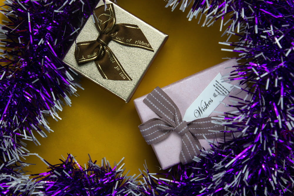 a gift wrapped in a purple and silver ribbon
