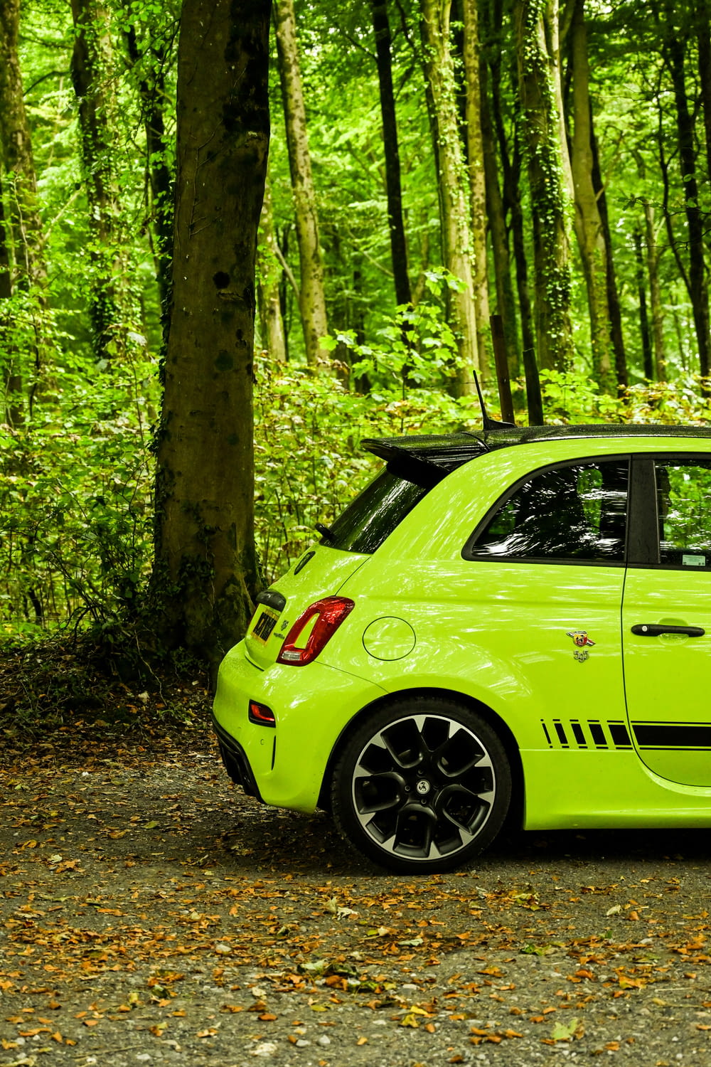 a bright green car parked in a wooded area