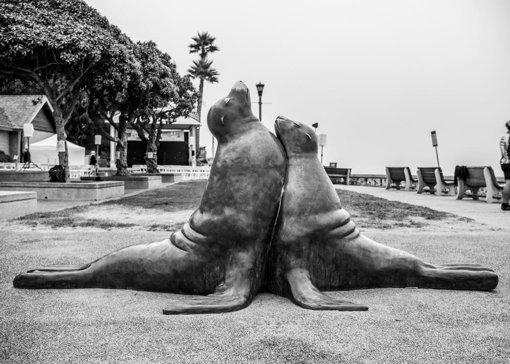 Un couple de statues assis sur un sol en ciment