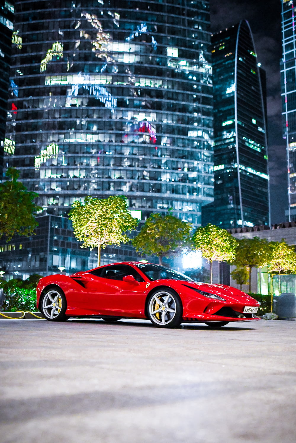 a red sports car parked in front of a tall building