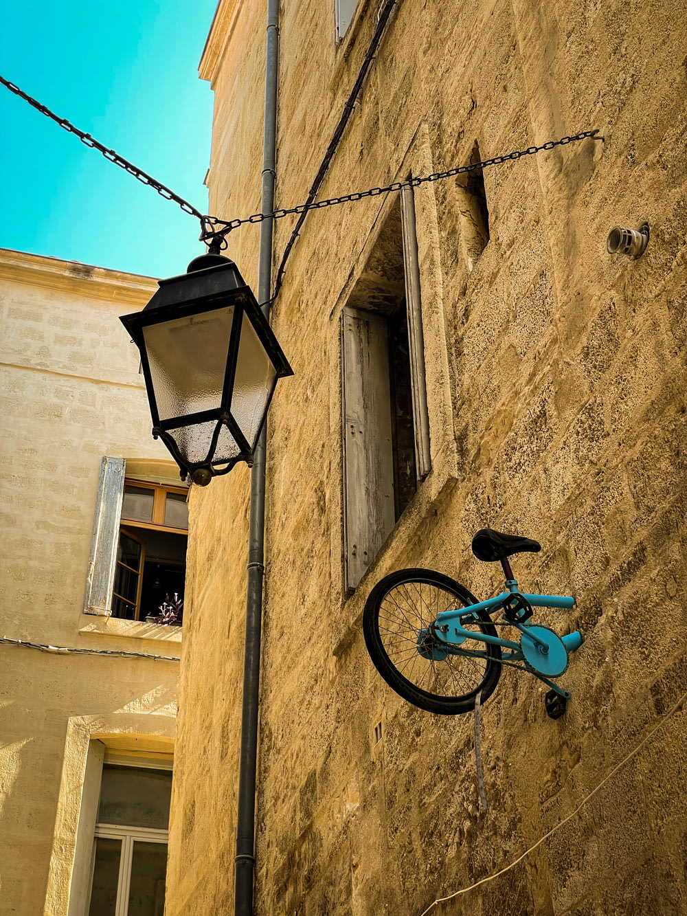 a bicycle is hanging on the side of a building