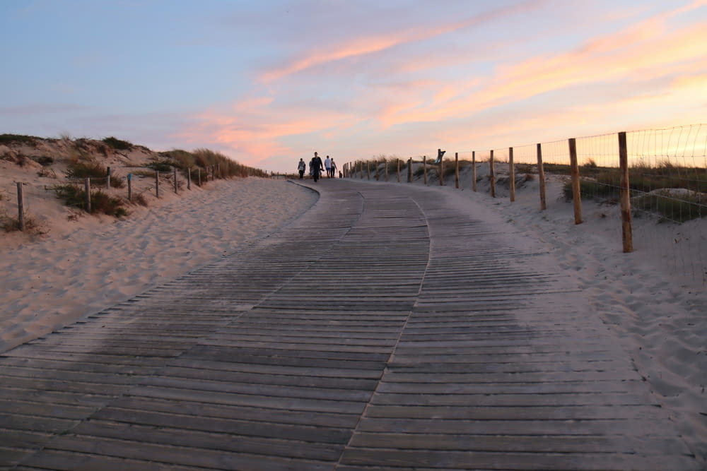 a boardwalk leading to the beach at sunset