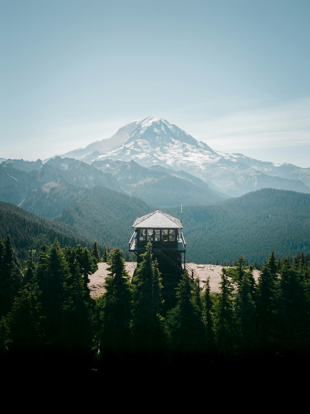 a gazebo on top of a hill with a mountain in the background