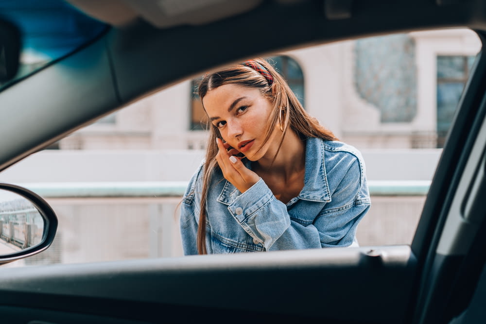 a woman sitting in a car talking on a cell phone