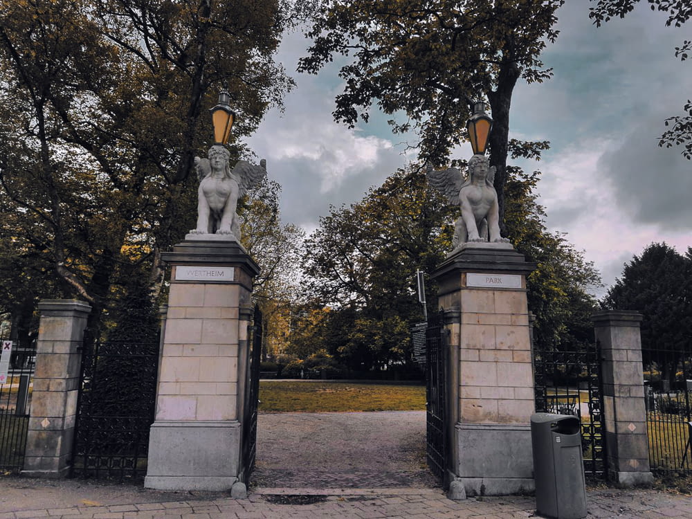 a couple of statues sitting on top of a gate