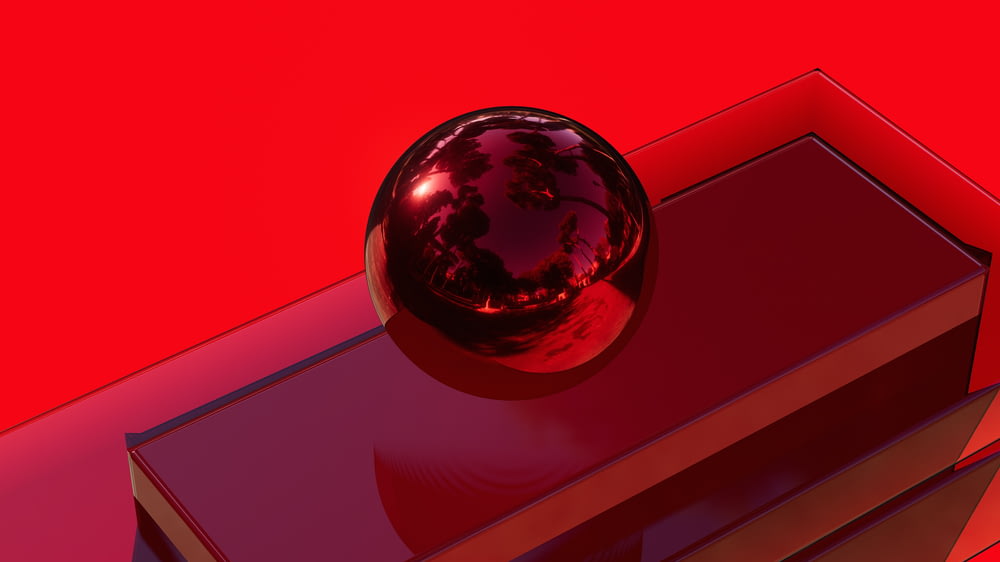 a shiny red object sitting on top of a book