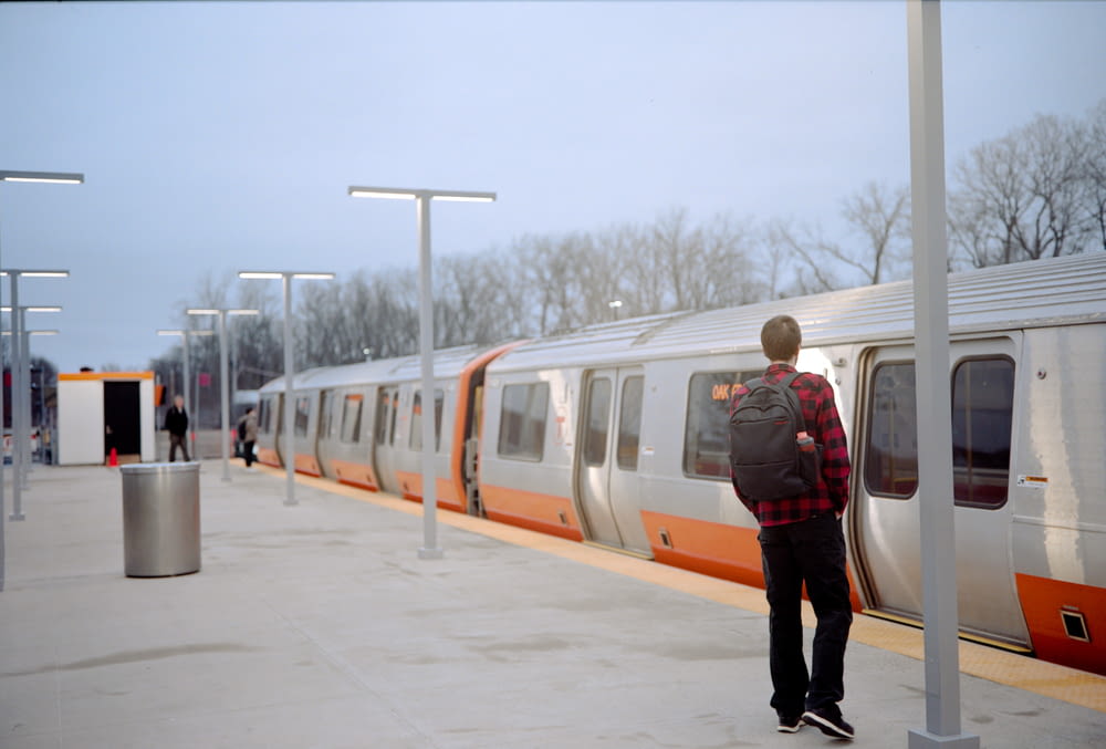 a man standing on a platform next to a train