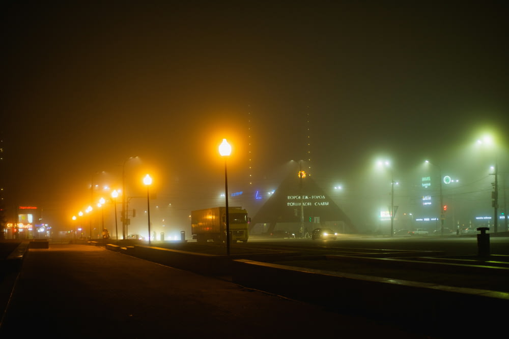 a foggy night on a city street with street lights