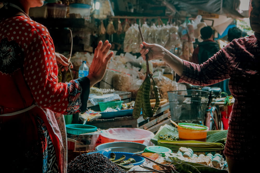 a woman standing next to another woman in a market