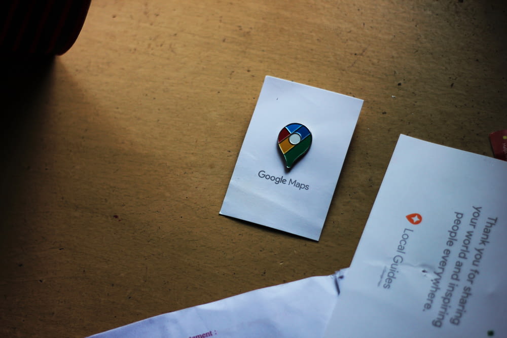 a google maps pin sitting on top of a piece of paper