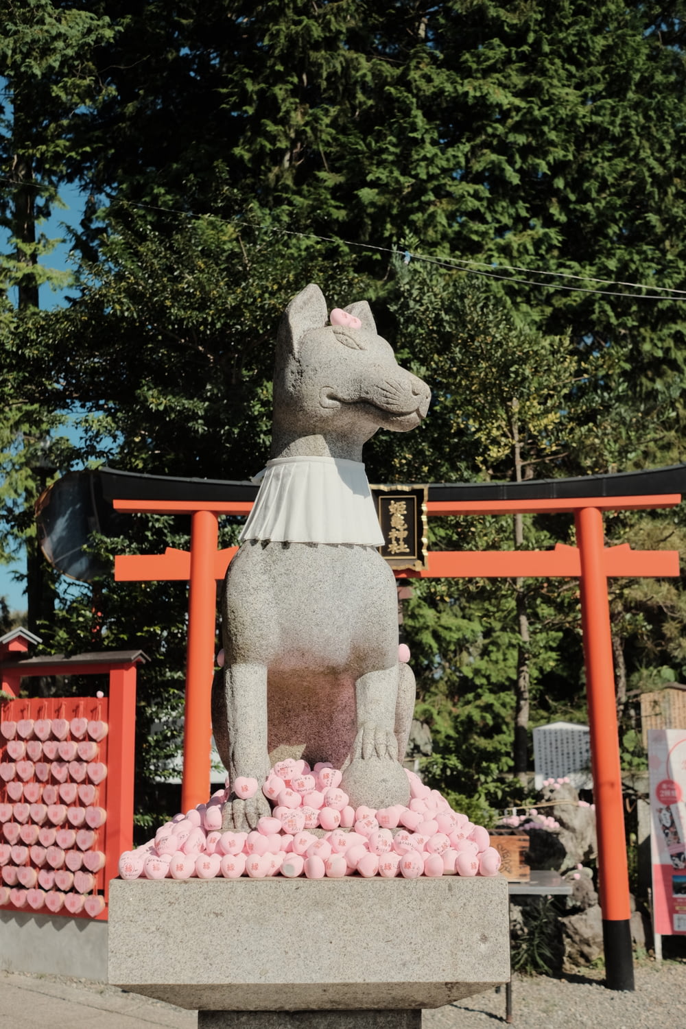 a statue of a dog with pink balls in front of it