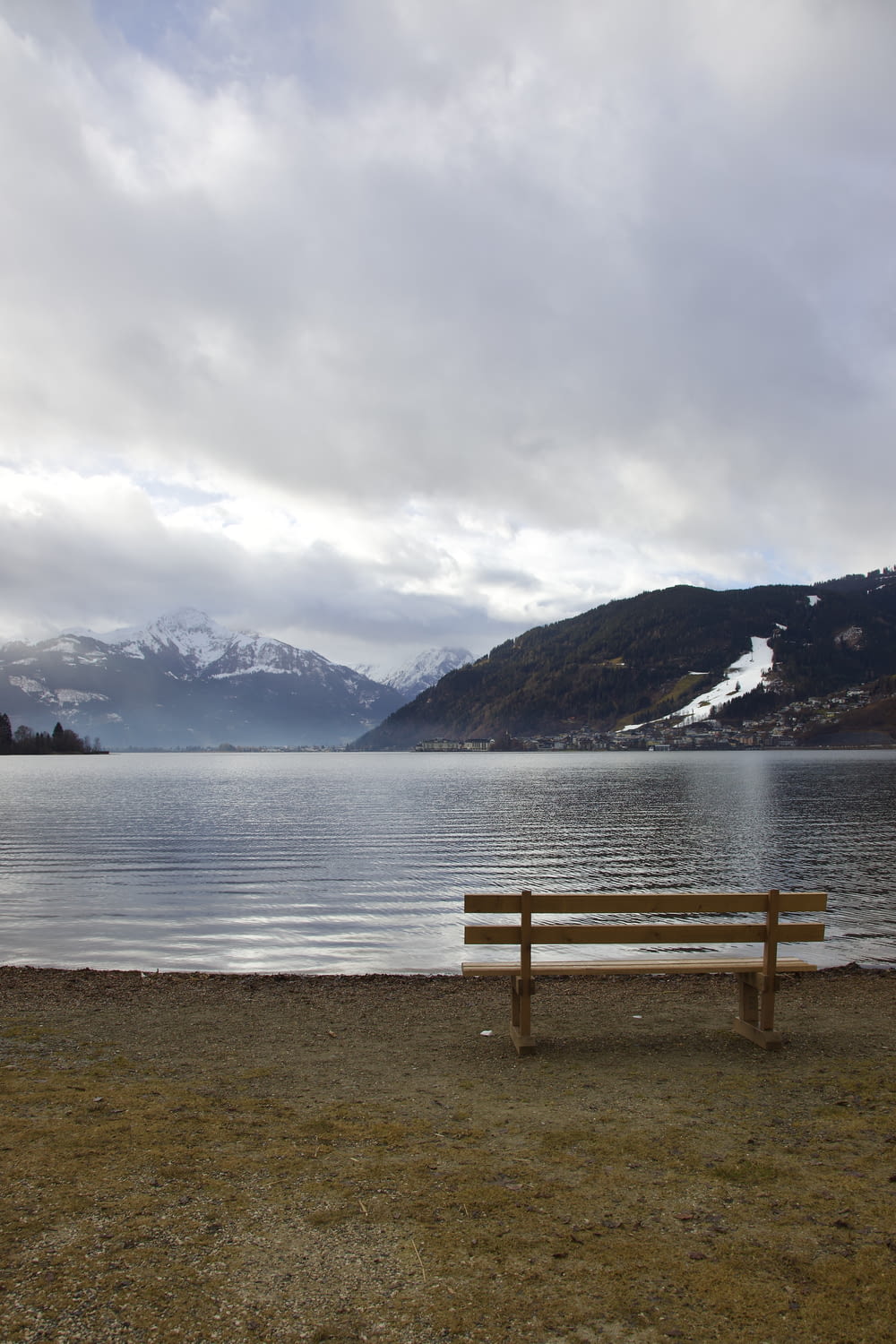 a wooden bench sitting on the shore of a lake