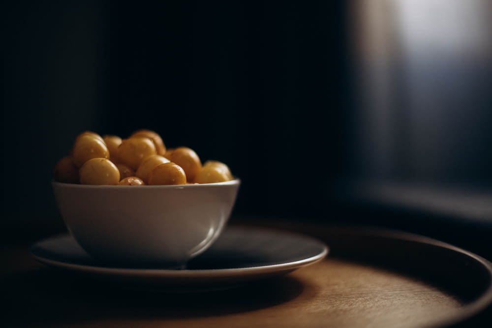 a white bowl filled with corn on top of a wooden table