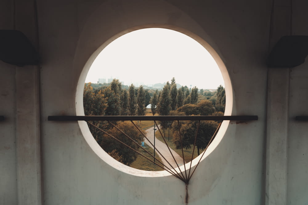 a round window with a view of a road through it