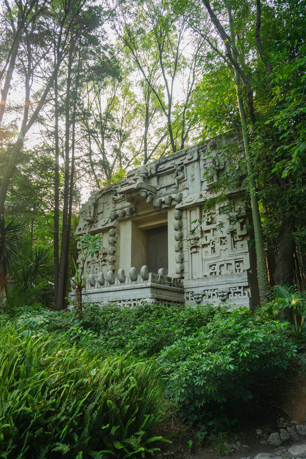 a stone structure in the middle of a forest