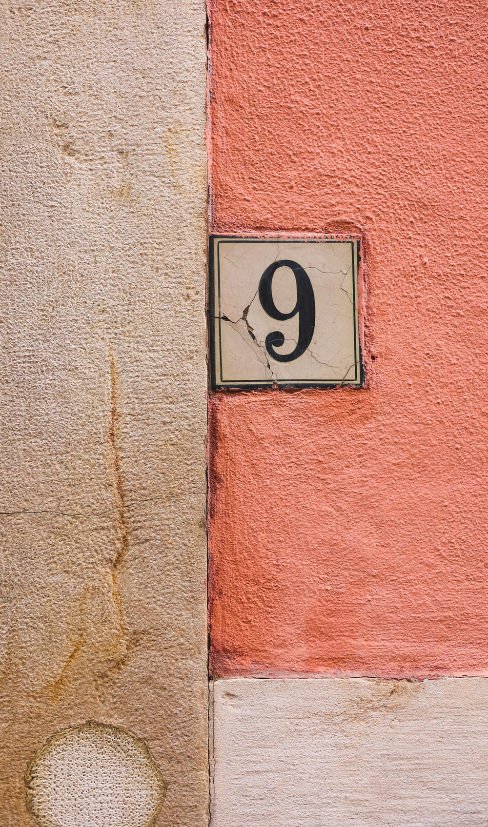 a number nine sign mounted to the side of a building